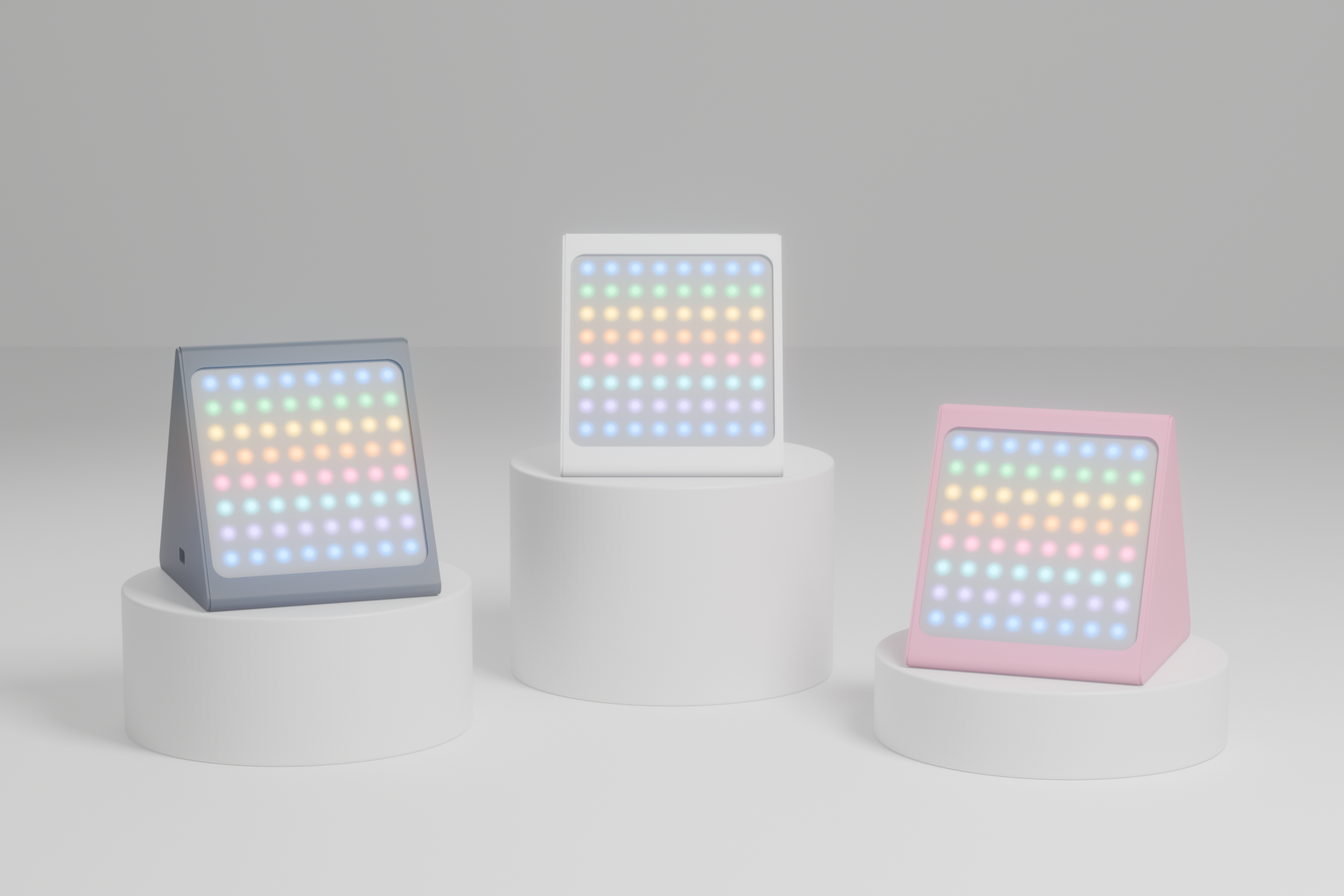 Three Ritlum mini units in white, sakura pink and blue grey, each on a white cylindrical riser
